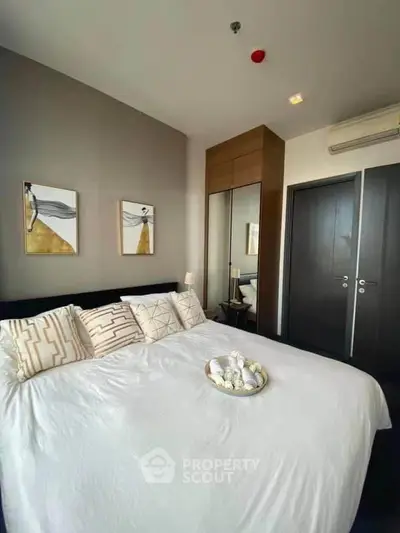 Modern bedroom with stylish decor and cozy ambiance, featuring a comfortable bed and elegant furnishings.