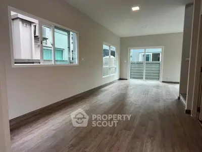 Spacious modern living room with large windows and wood flooring