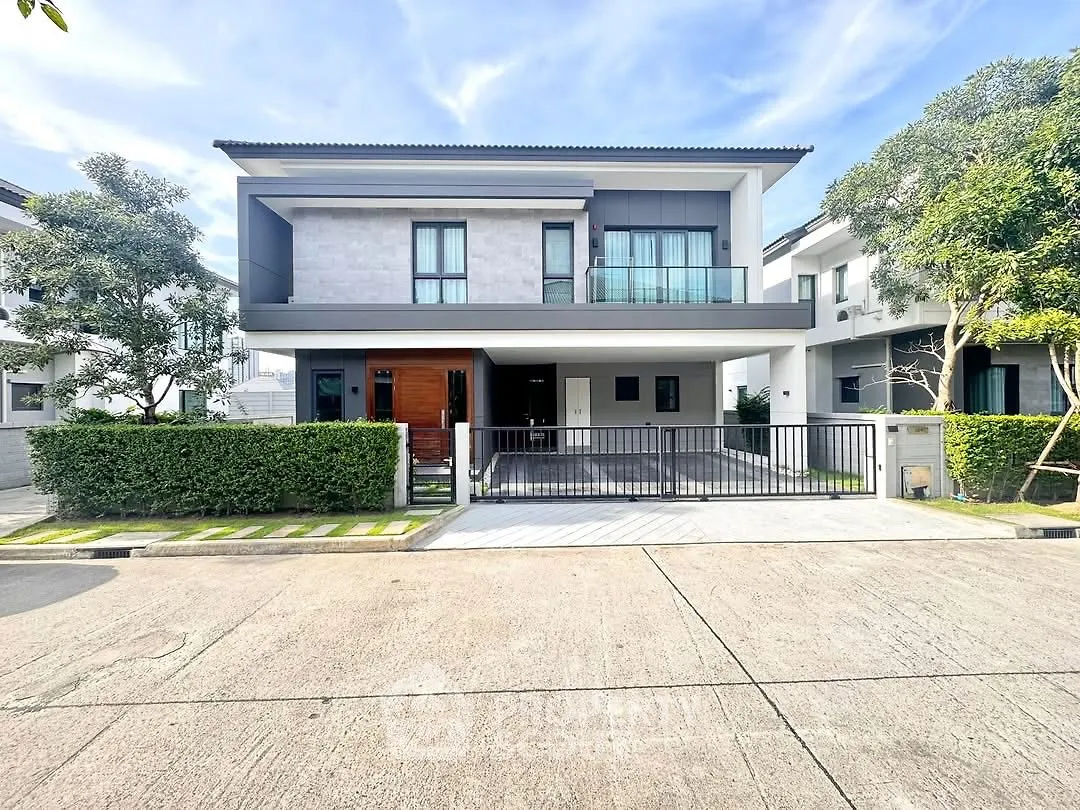 Modern two-story house with sleek design and lush greenery in a serene neighborhood.