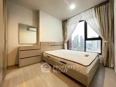 Modern bedroom with city view, featuring sleek furniture and large windows.