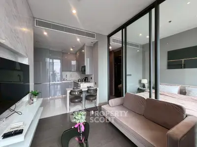 Modern open-plan living room with sleek kitchen and cozy bedroom in luxury apartment.