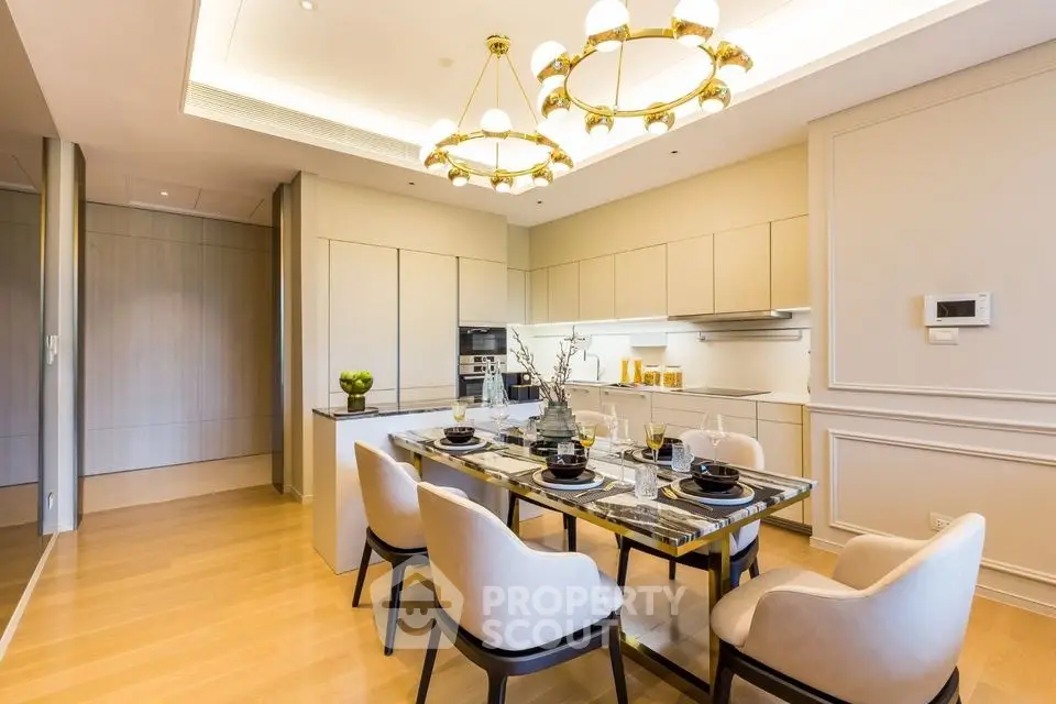 Luxurious dining area with elegant lighting and modern kitchen in open layout apartment.