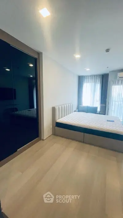 Spacious bedroom with modern design and large windows for natural light.