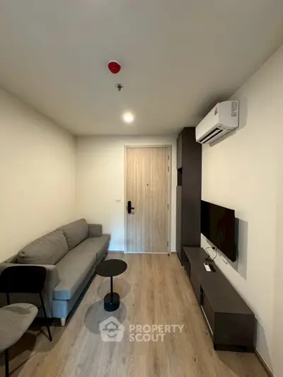 Modern living room with sleek furniture and wall-mounted TV