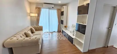 Modern living room with elegant sofa and built-in shelves, featuring wooden flooring and natural light.