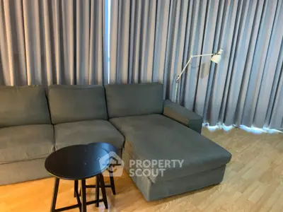 Modern living room with stylish gray sofa and elegant floor lamp