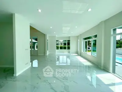 Spacious modern living room with large windows and marble flooring