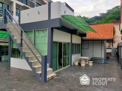 Modern two-story building with outdoor staircase and tiled patio