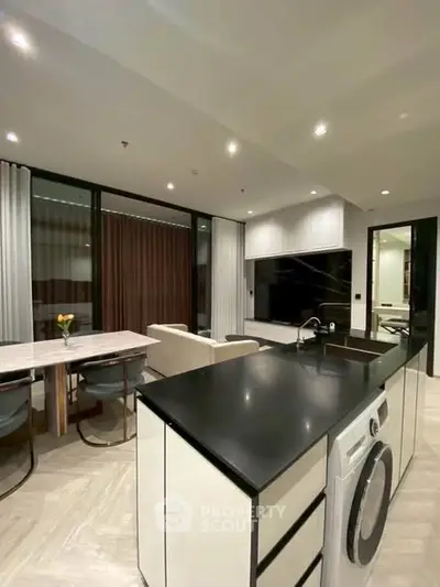 Modern open-plan kitchen and living area with sleek design and integrated appliances.