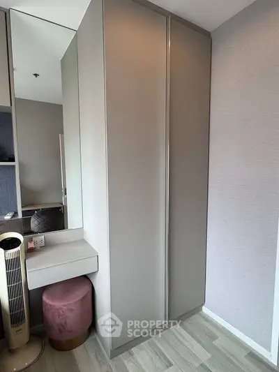 Modern bedroom with sleek wardrobe and vanity area, featuring stylish decor and elegant design.