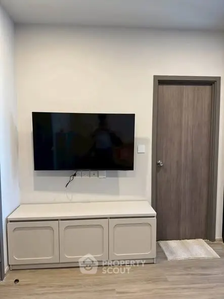 Modern living room with wall-mounted TV and sleek storage unit