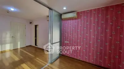 Spacious living room with pink accent wall and sliding glass partition in modern apartment.
