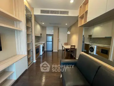 Modern apartment interior with open kitchen and cozy living area, featuring sleek appliances and stylish furnishings.
