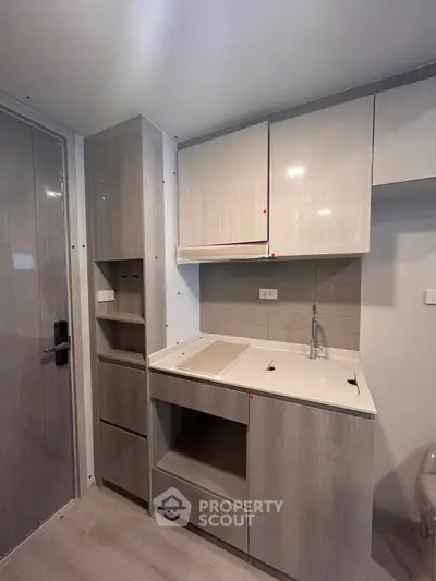 Modern compact kitchen with sleek cabinetry and integrated appliances in a stylish apartment.