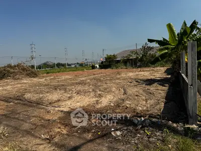 Vacant land plot with clear skies and surrounding greenery, ideal for development opportunities.