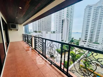 Spacious balcony with stunning city and ocean views in modern high-rise building.