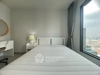 Modern bedroom with city view, featuring a cozy bed, desk, and large window.