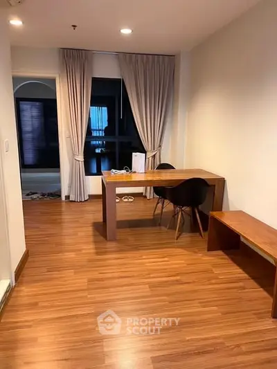 Modern study area with wooden flooring and sleek furniture in a stylish apartment.