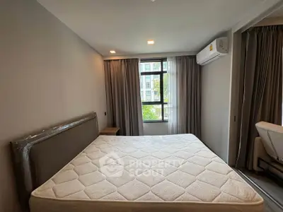Spacious bedroom with large window and modern air conditioning unit in a stylish apartment.
