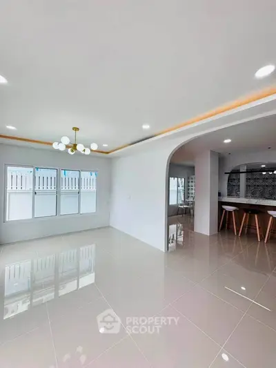 Spacious modern living room with elegant lighting and glossy tiled floors