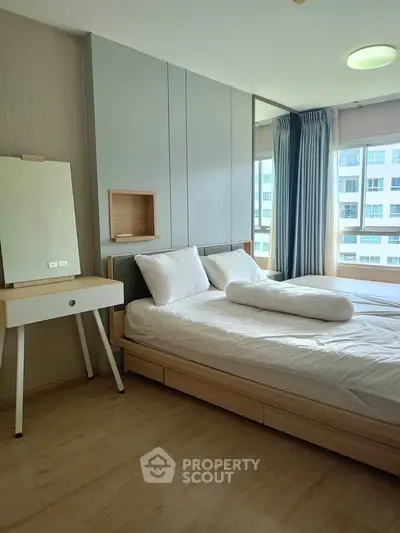 Modern bedroom with natural light and stylish decor in a high-rise apartment.