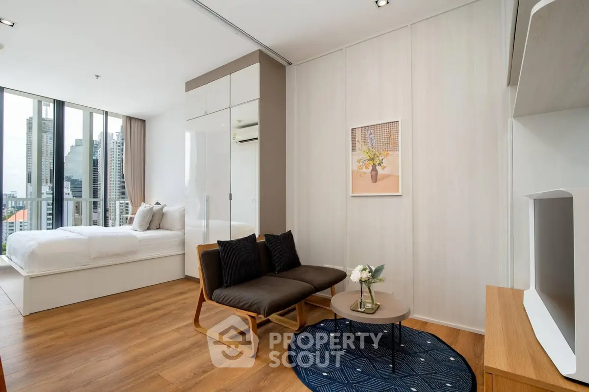 Modern studio apartment with city view, featuring cozy living area and stylish bedroom.