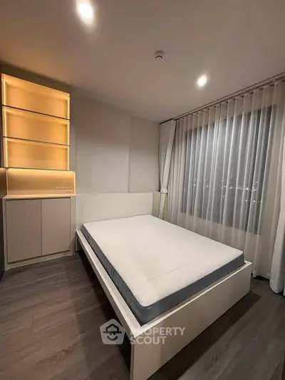 Modern bedroom with sleek design and ambient lighting, featuring a comfortable bed and stylish shelving.