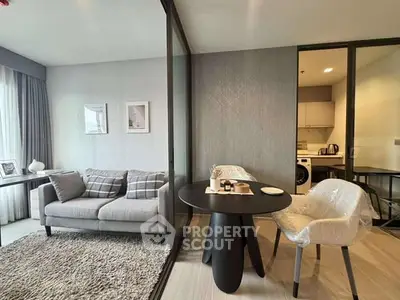 Modern living room with stylish decor and glass partition in contemporary apartment.