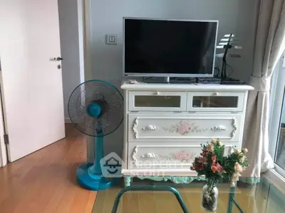 Charming living room with vintage dresser, TV, and elegant decor.