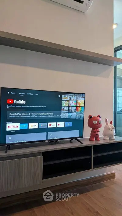 Modern living room with sleek TV setup and stylish shelving, perfect for entertainment enthusiasts.