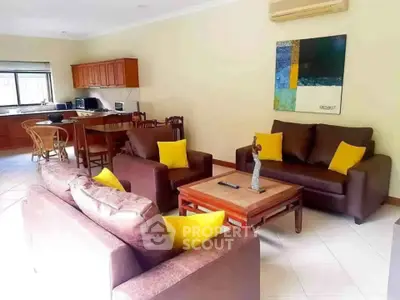 Spacious living room with modern furniture and open kitchen layout.