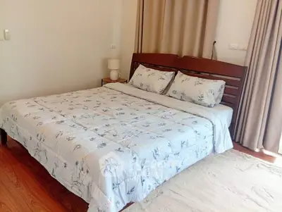Cozy bedroom with wooden flooring and elegant bedding in a serene setting.