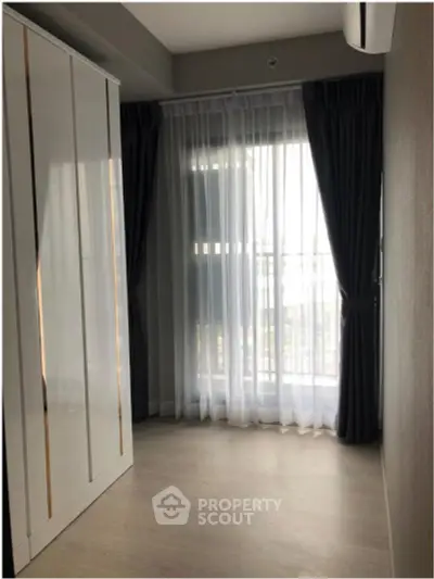 Bright bedroom with large window and elegant curtains