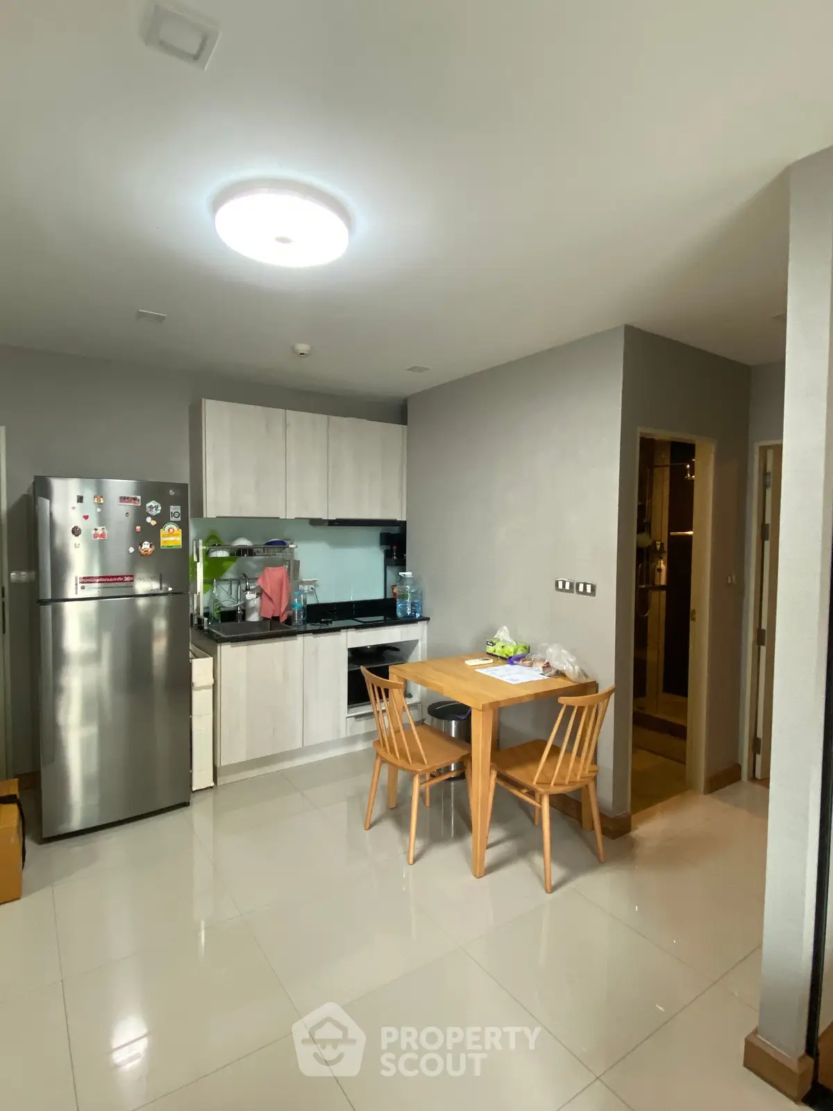 Modern kitchen with sleek cabinetry and dining area in contemporary apartment