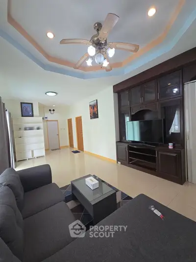 Spacious living room with modern ceiling fan and entertainment center