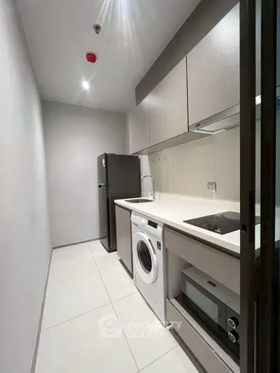 Modern compact kitchen with sleek appliances and minimalist design