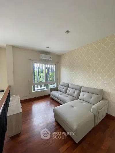 Stylish living room with modern sofa and elegant wallpaper, featuring hardwood floors and natural light.