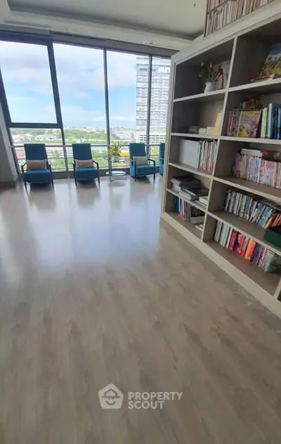 Spacious modern living room with large windows and built-in bookshelves offering stunning city views.