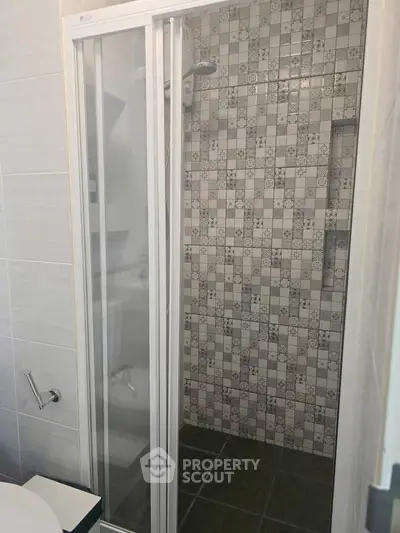 Modern bathroom with stylish tiled shower and glass door enclosure