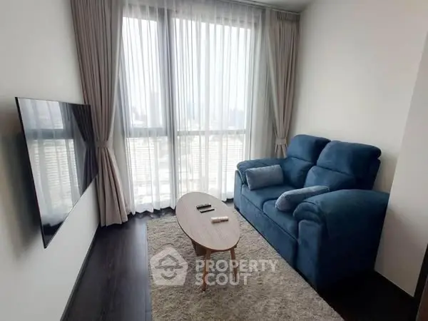Cozy living room with modern decor and large windows offering city views.