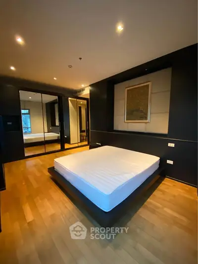 Luxurious bedroom with elegant hardwood flooring and modern decor in a high-end apartment.