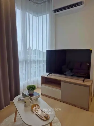 Modern living room with sleek TV setup and natural light from large window.
