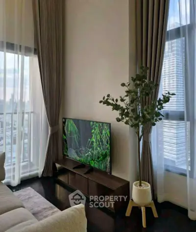 Modern living room with floor-to-ceiling windows and city view, featuring elegant decor and a flat-screen TV.