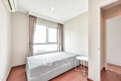 Bright minimalist bedroom with large window and simple furnishings