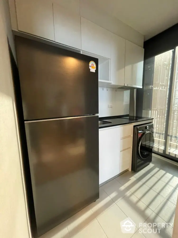 Modern kitchen with sleek appliances and ample natural light