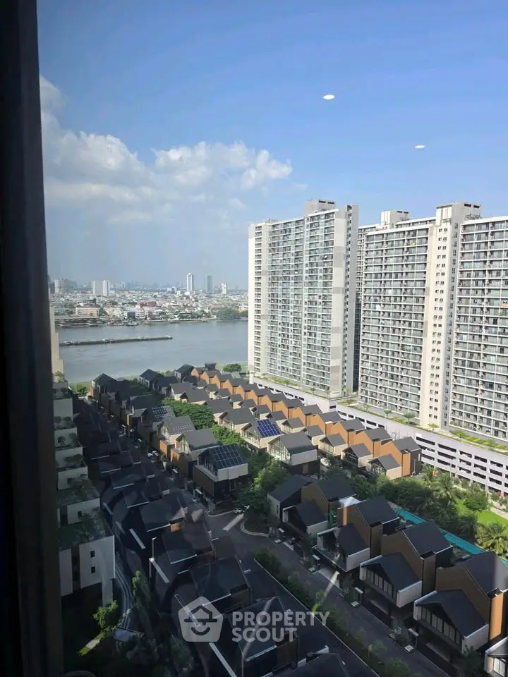 Stunning cityscape view from high-rise apartment overlooking river and modern residential area.
