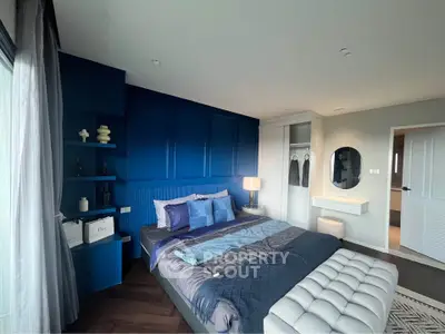 Modern bedroom with stylish blue accent wall and cozy decor