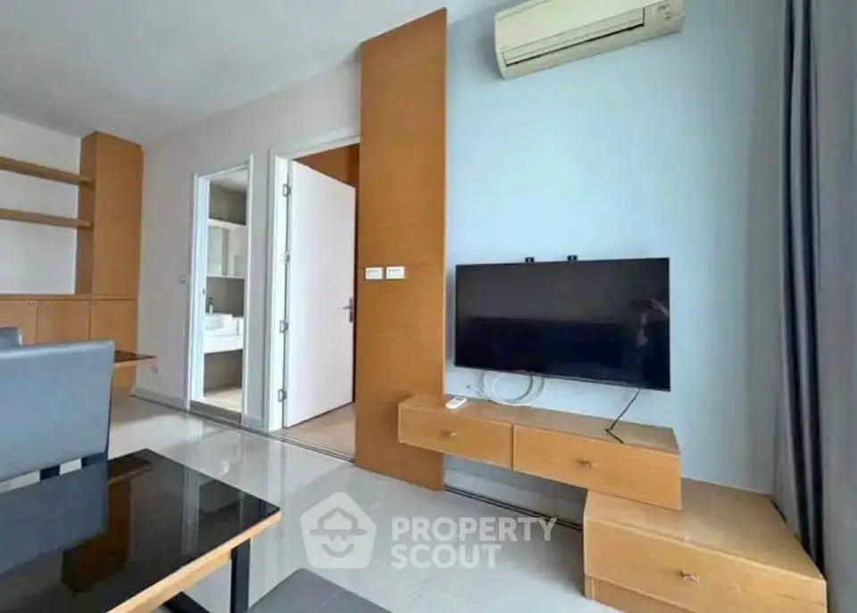 Modern living room with sleek furniture and wall-mounted TV in a stylish apartment.