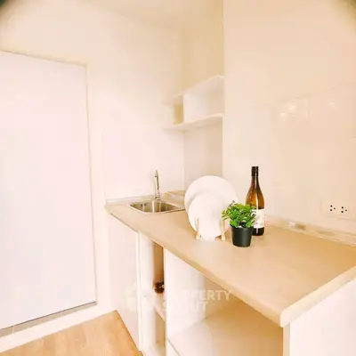 Modern minimalist kitchen with sleek countertops and open shelving, perfect for compact living spaces.