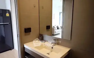 Modern bathroom with sleek sink and large mirror in contemporary apartment.